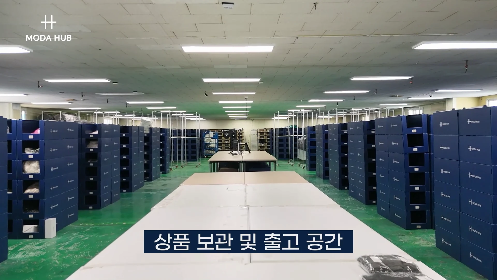 모다허브 2센터 상품 보관·출고 공간 — 모다허브 박스가 늘어선 통로와 행거 랙